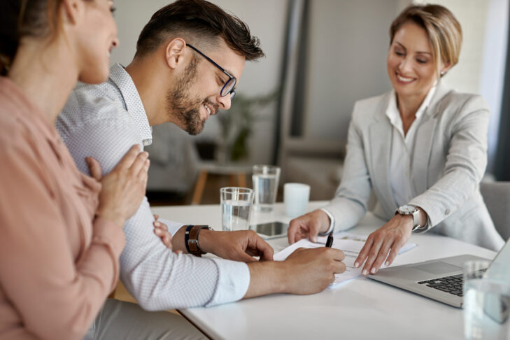 happy man his wife having meeting with financial advisor signing agreement office 1 scaled