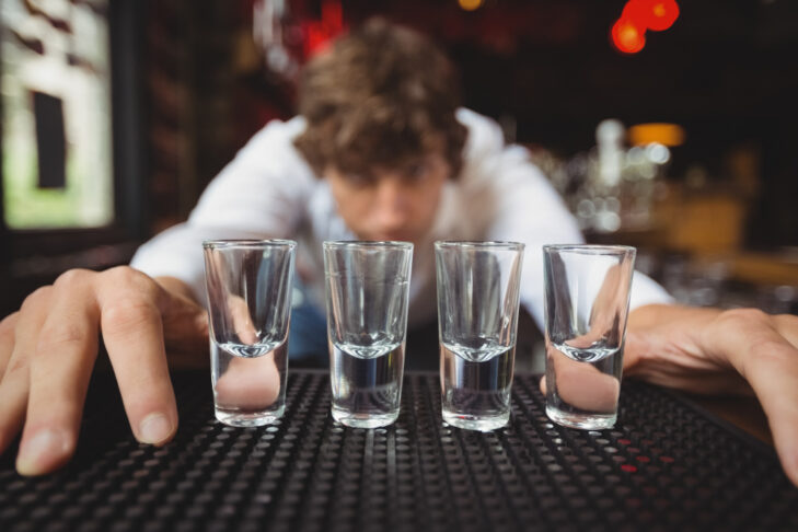 bartender preparing lining shot glasses alcoholic drinks bar counter
