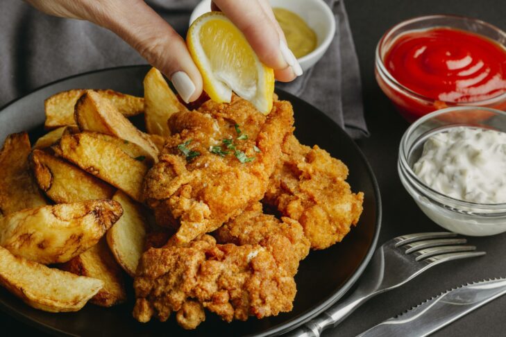 woman squeezing lemon juice fish chips platter 1 scaled