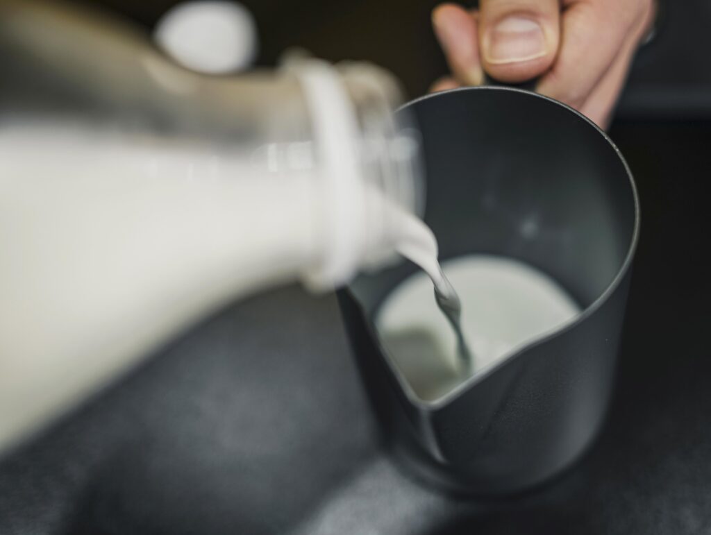 high angle barista pouring milk