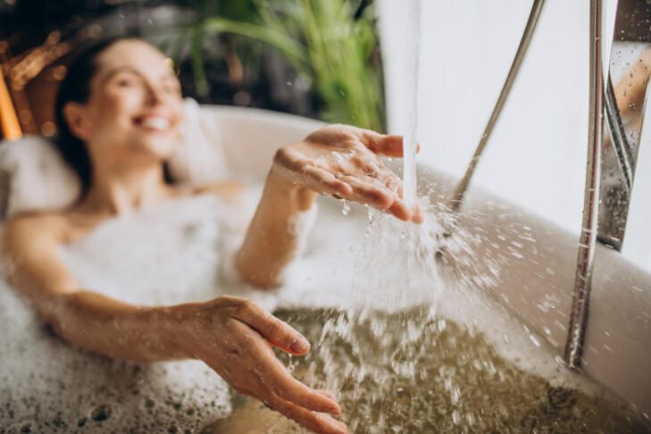 woman relaxing bath with bubbles