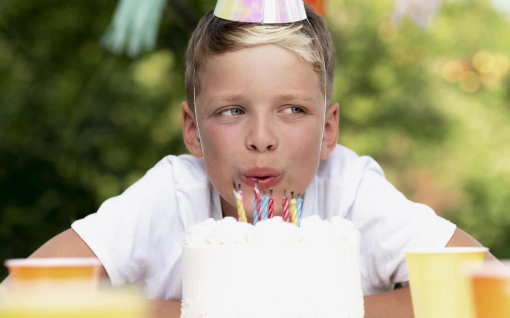 close up kid blowing out candles